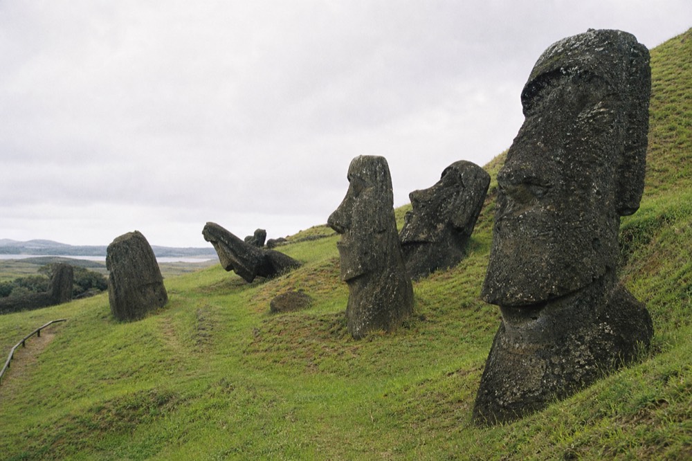 Rows of weathered moai heads emerging from the grassy volcanic slope of the Rano Raraku quarry