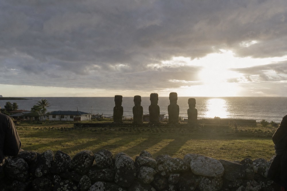 View from a low stone wall on the edge of a small town looking out at a dark sky over the ocean